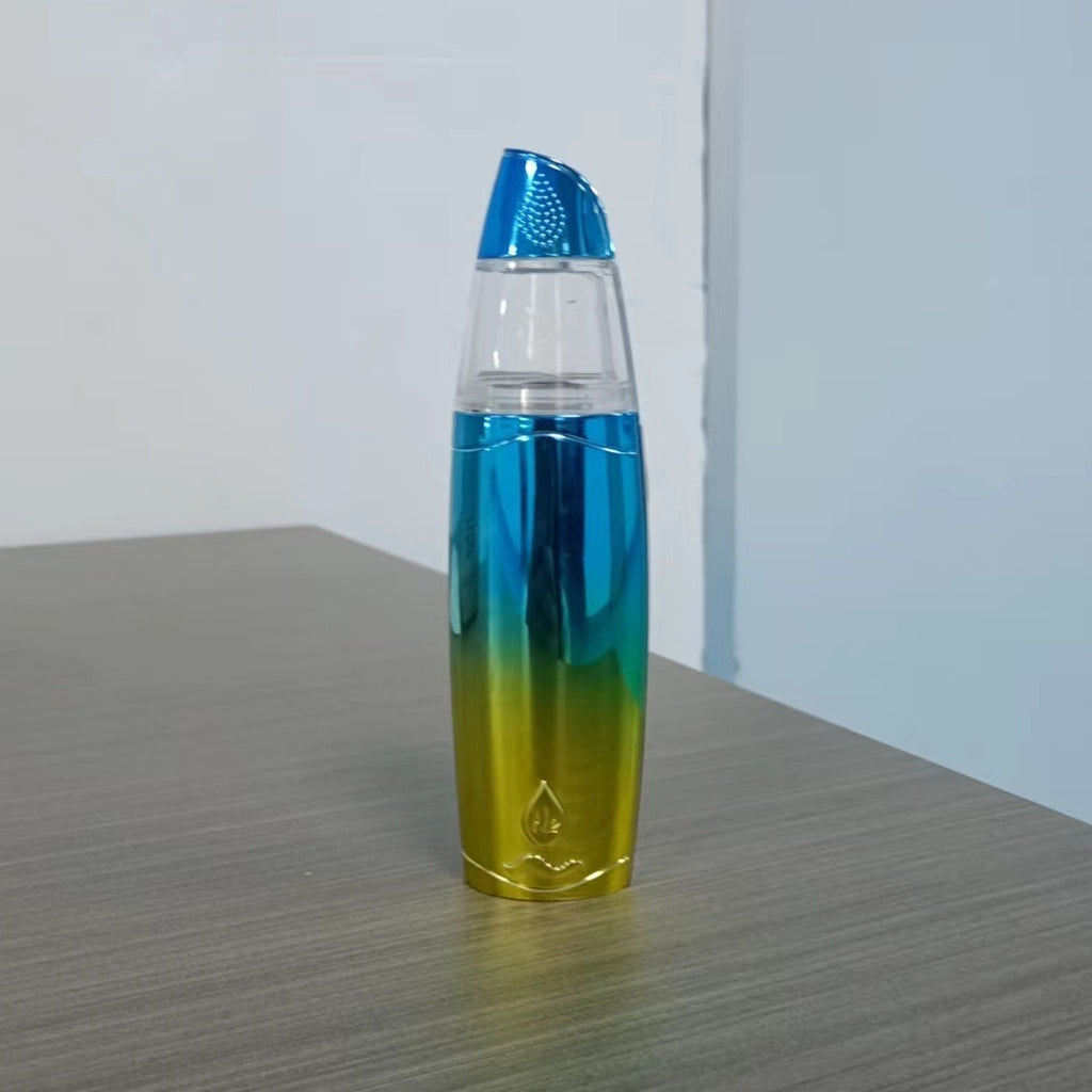 Gradient blue to yellow bottle on a gray surface with a white background