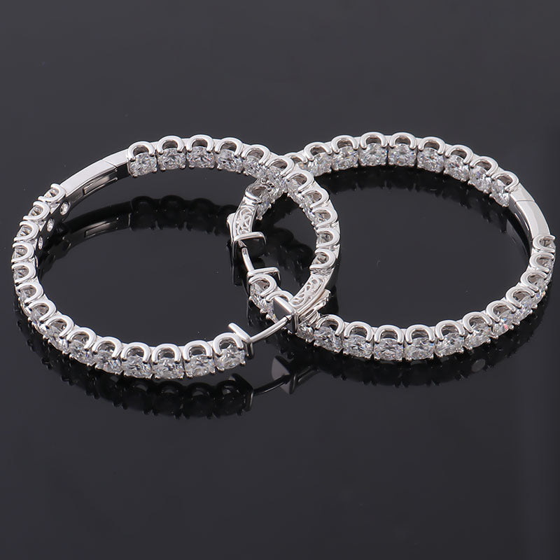Pair of silver hoop earrings on a black background