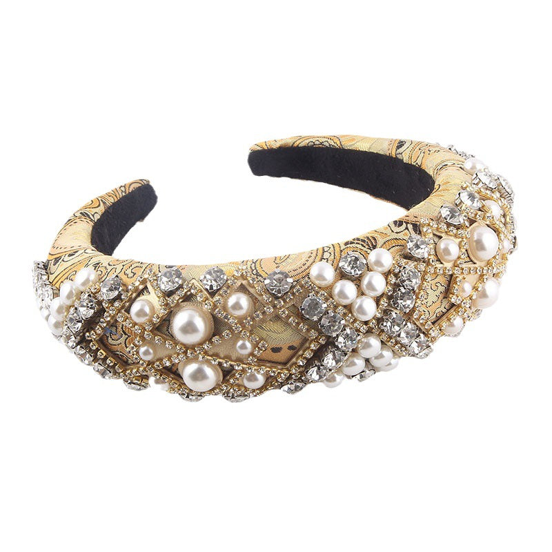 Decorative headband with pearls and gold patterns on a white background