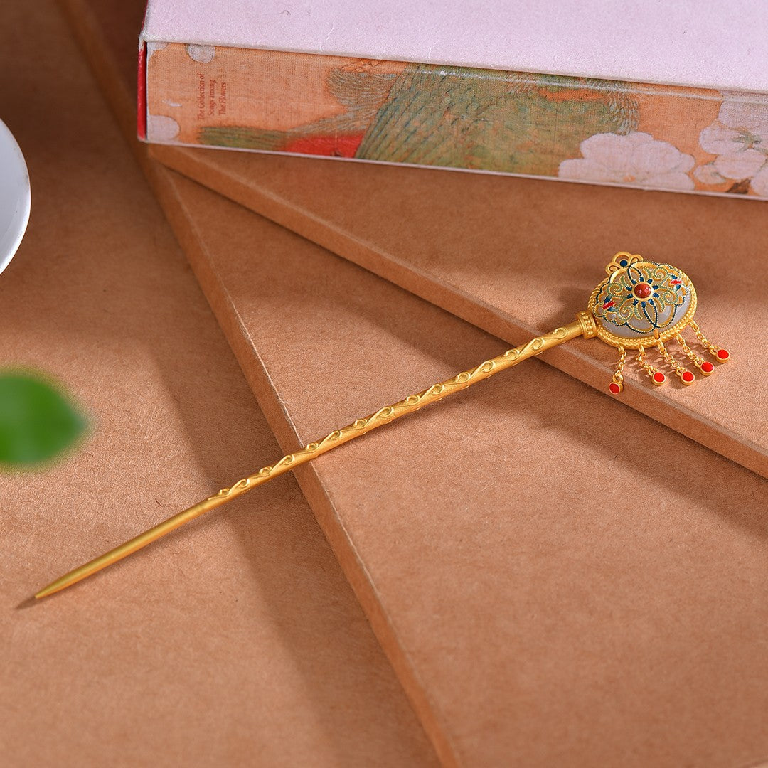 Decorative gold hairpin with intricate design on a brown surface