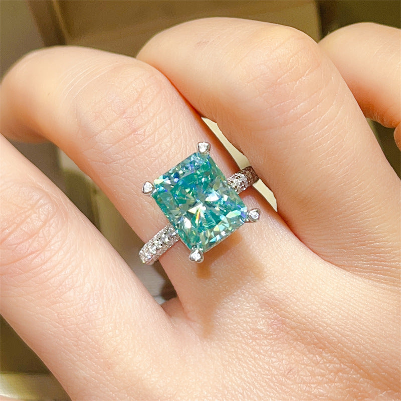 Ring with a large green gemstone on a finger