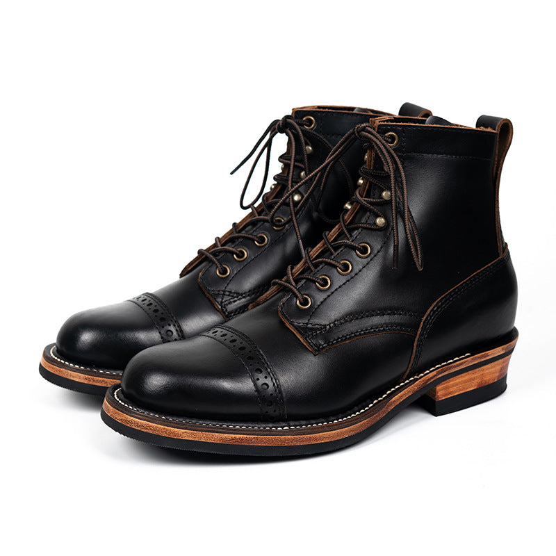 Pair of black leather boots with brown soles on a white background