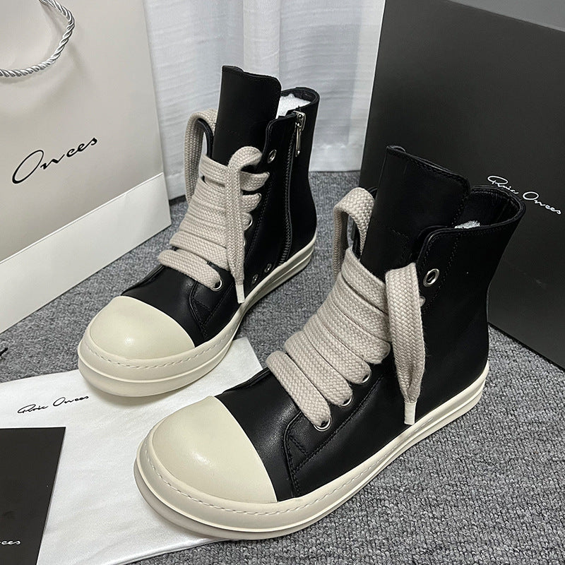 Black and white high-top sneakers on a gray surface with 'Onwees' branding.