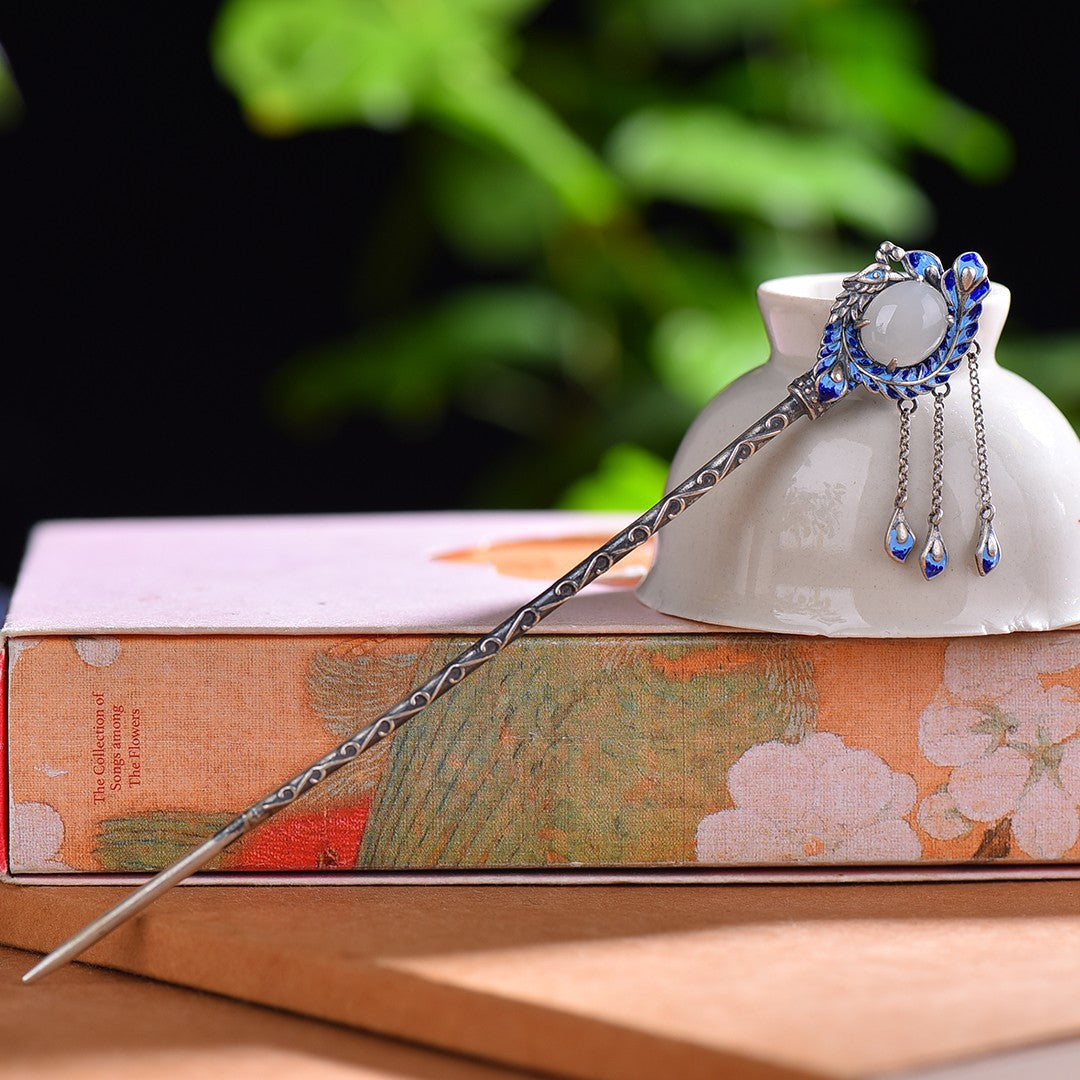 Decorative hairpin with blue and silver elements on a book with floral design