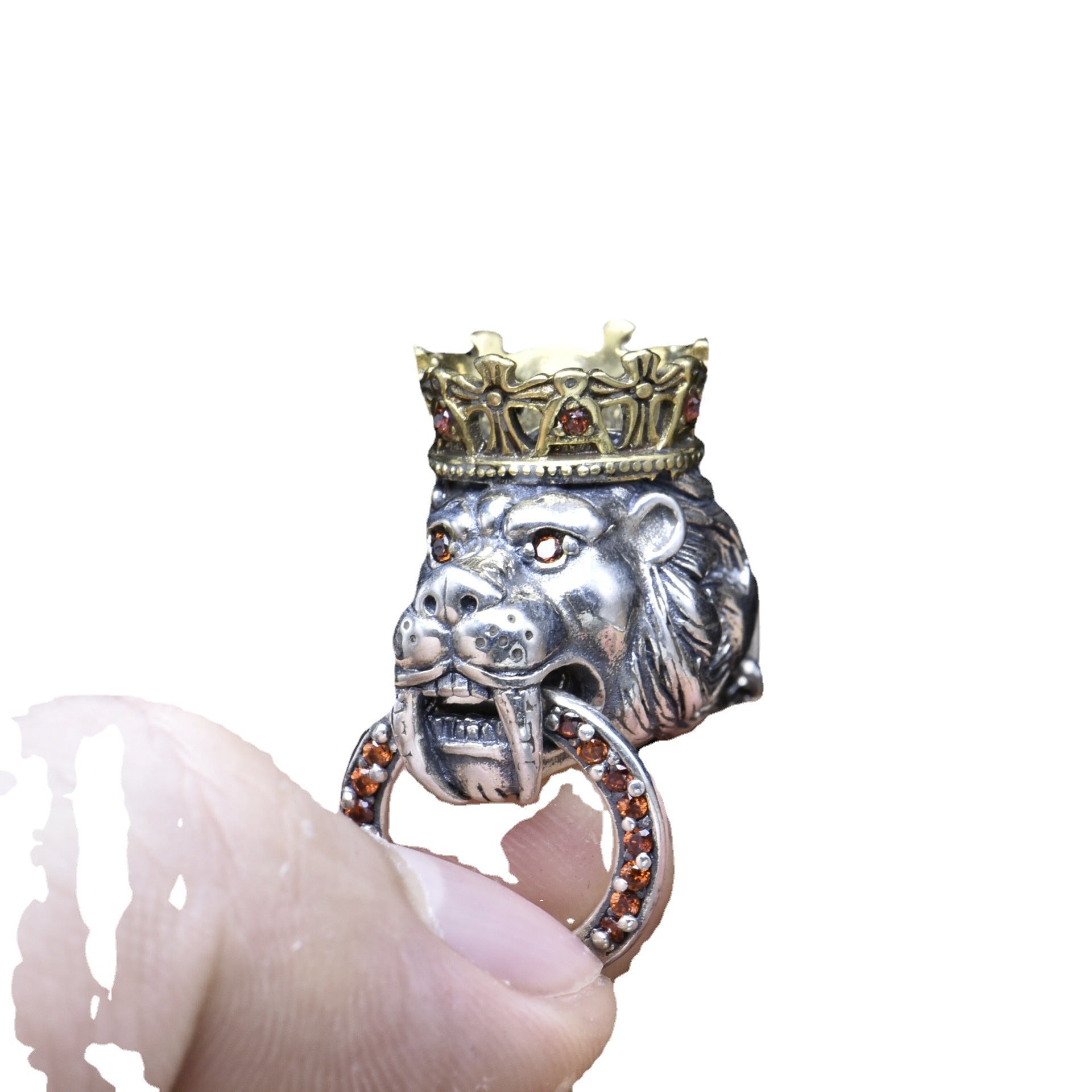 Silver lion head ring with a gold crown held by a hand on a white background