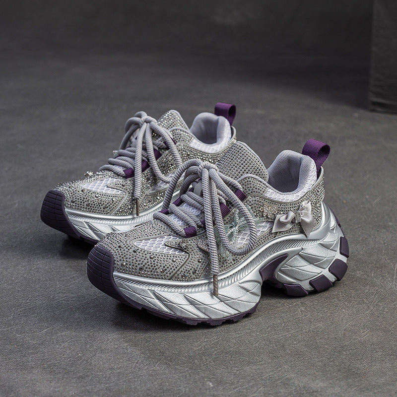 Pair of gray and purple sneakers on a dark surface