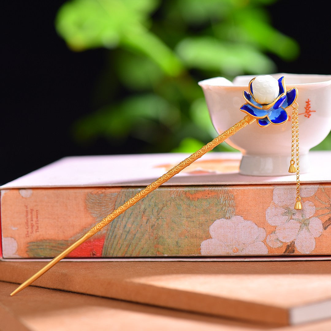 Decorative hairpin with blue and gold design on a book with floral design