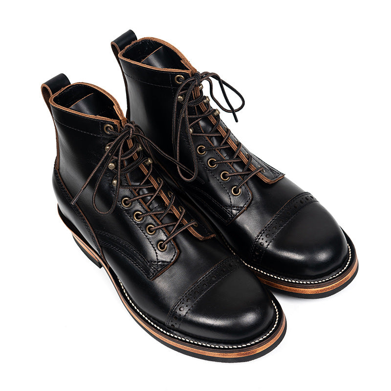 Pair of black leather boots with brown accents on a white background