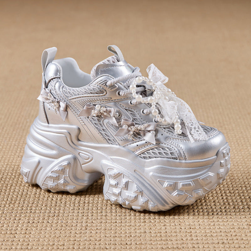 Silver sneaker with lace details on a beige background
