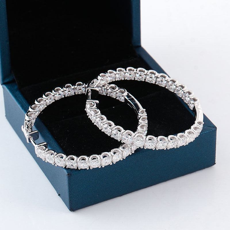 Pair of silver hoop earrings in an open blue jewelry box.