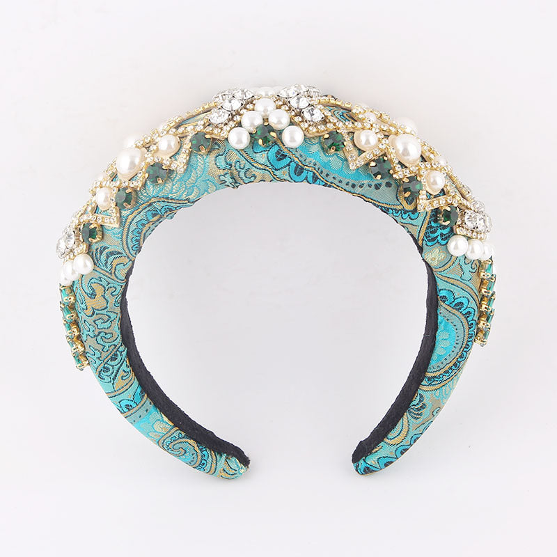 Decorative headband with turquoise pattern and pearl embellishments on a white background