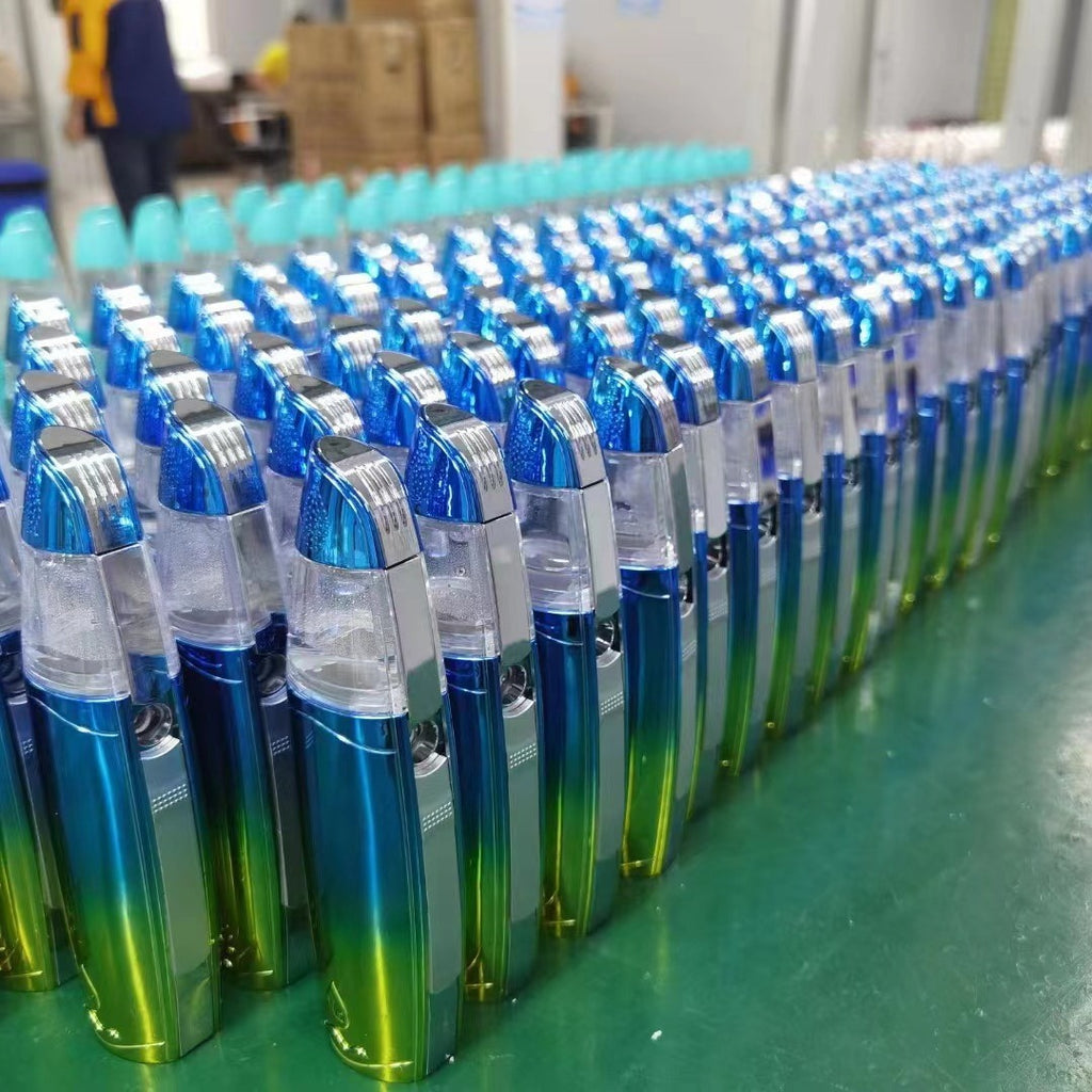 Row of blue and green gradient lighters on a green surface with a blurred background.
