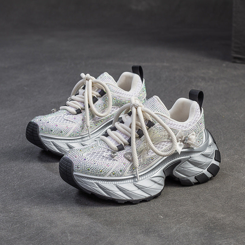 White sneakers with black soles on a gray surface