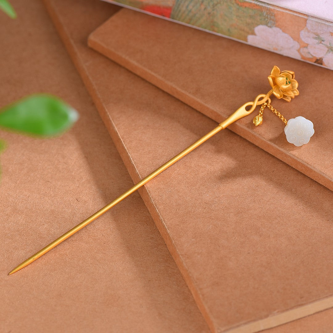 Gold hairpin with decorative elements on a brown surface