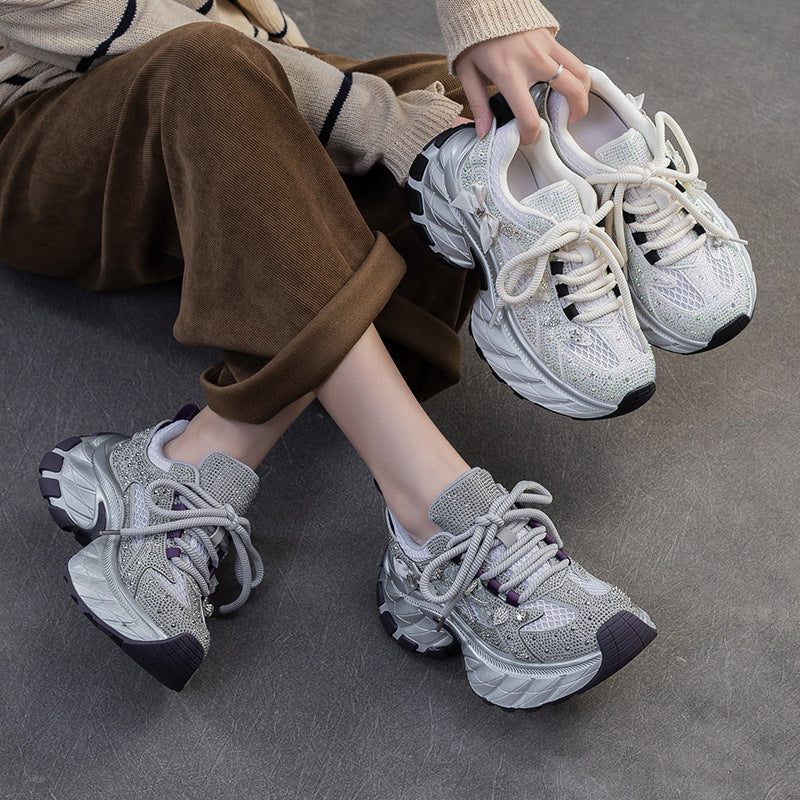 Person wearing sparkly sneakers on a gray floor