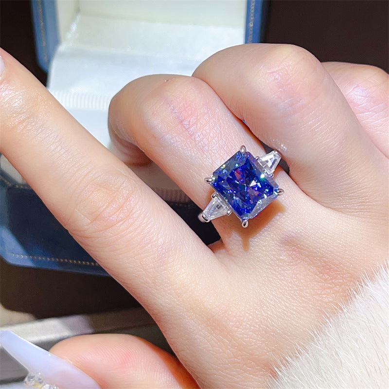 Blue gemstone ring on a finger with a blurred background