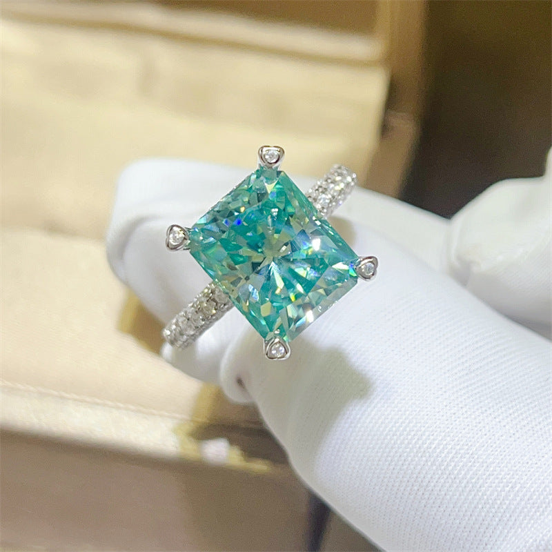 Ring with a green gemstone on a white mannequin hand