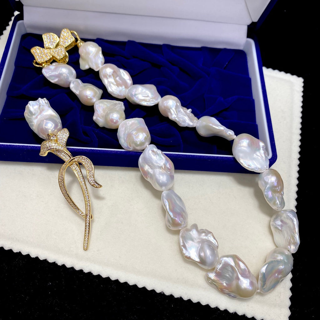 Pearl necklace with gold pendants on a blue cushioned box