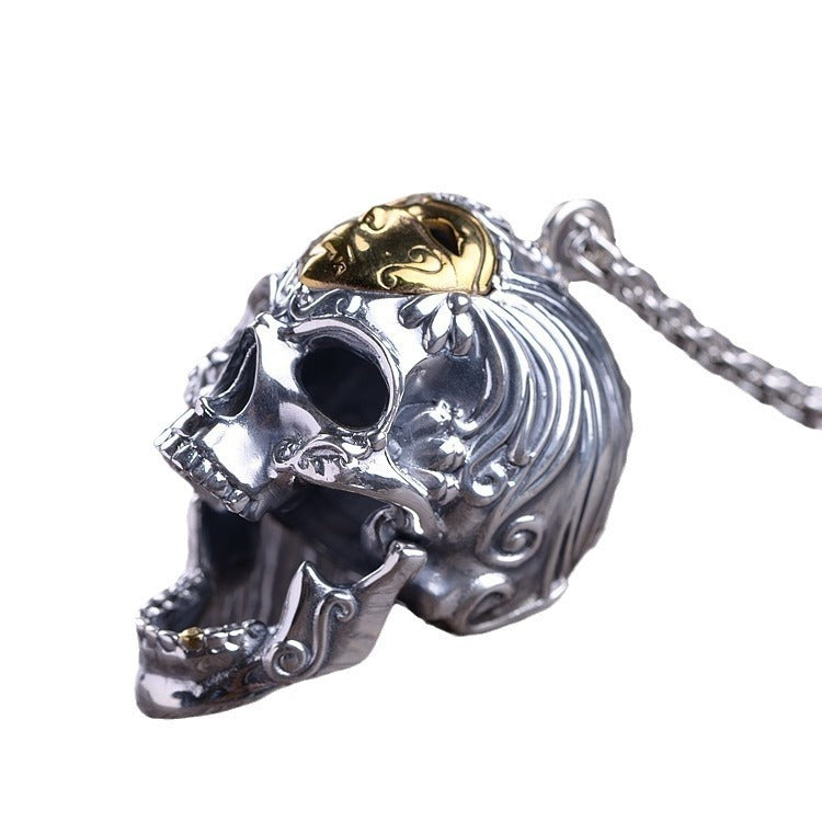 Skull-shaped pendant with gold and silver details on a white background