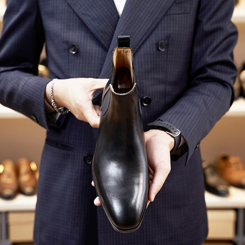 Person holding a black leather shoe with a blurred background of shoes on shelves.
