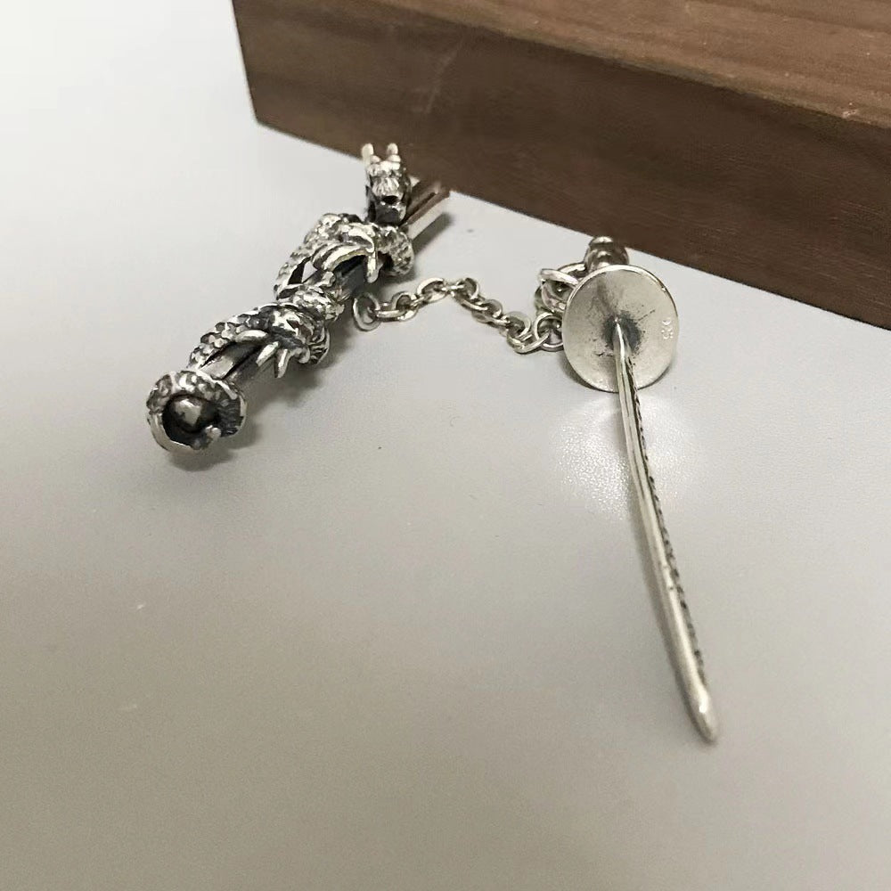 Silver hairpin with decorative elements on a white surface