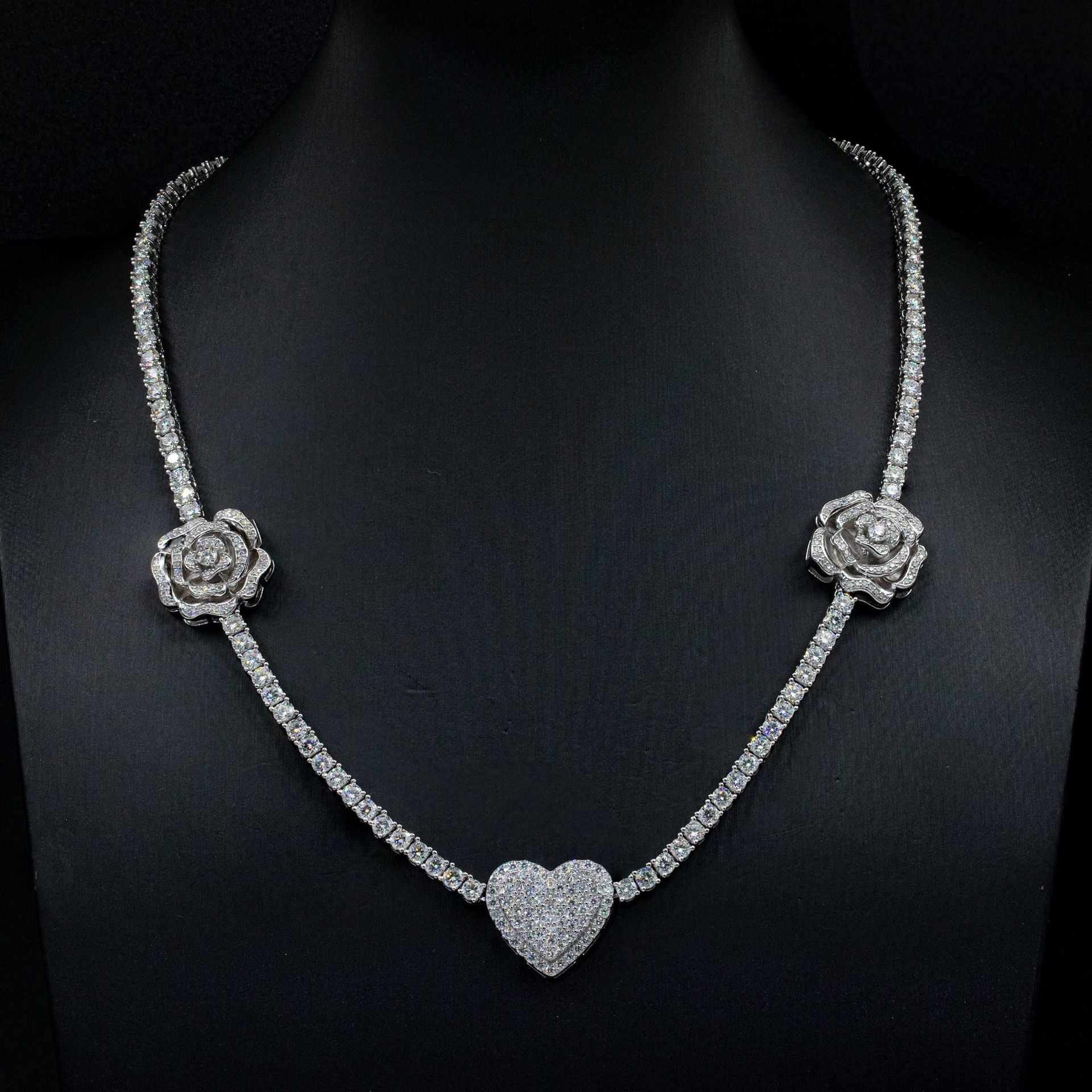 Diamond necklace with rose and heart designs on a black background