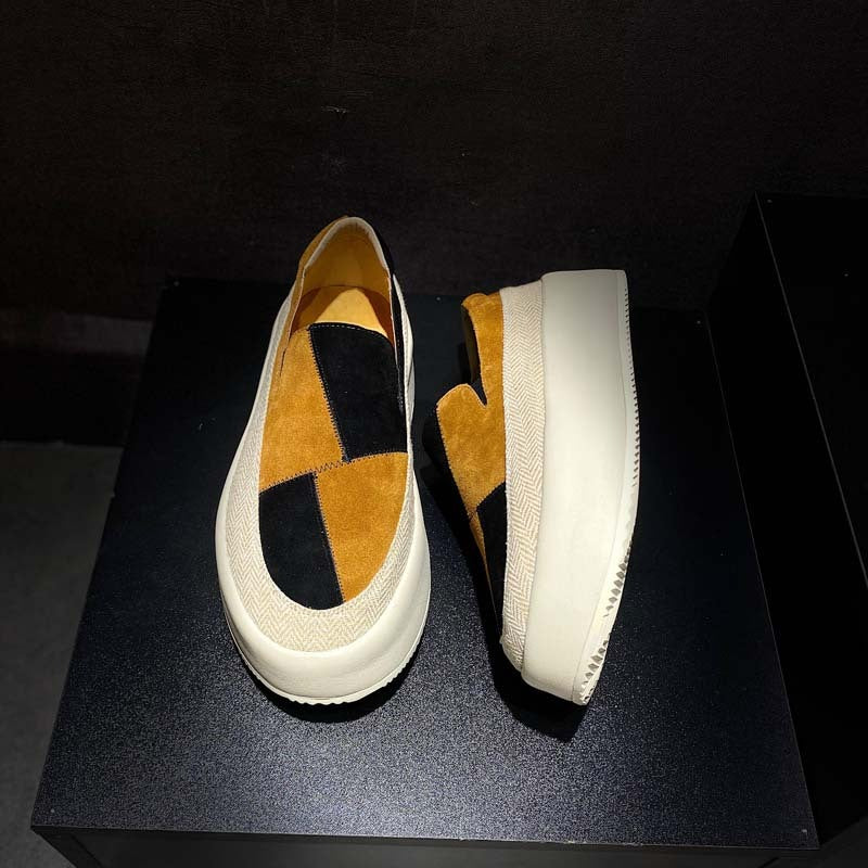 Pair of checkered slip-on shoes on a black platform