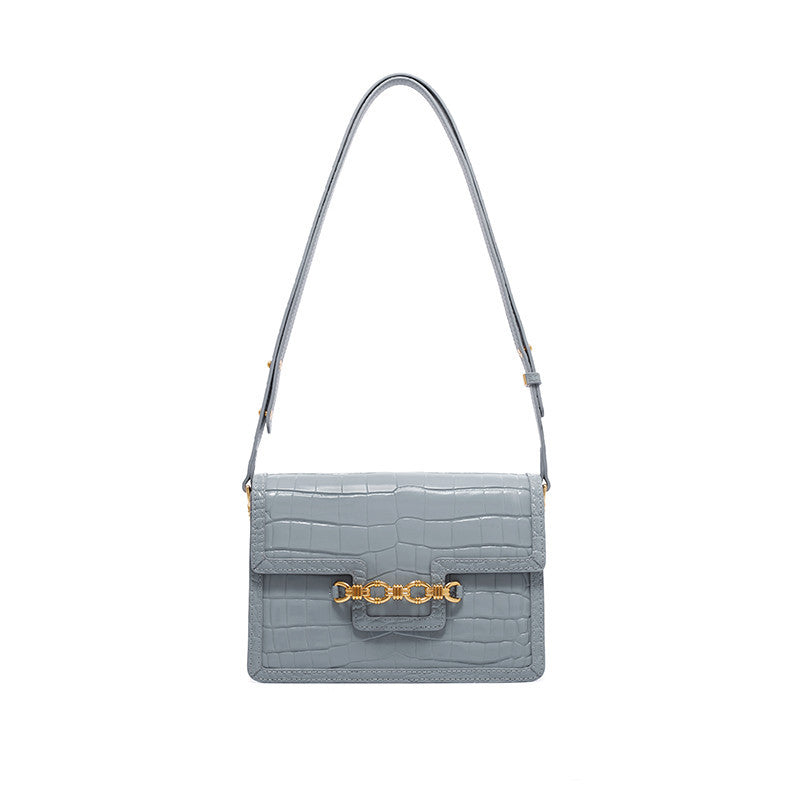 Light blue handbag with gold chain detail on a white background