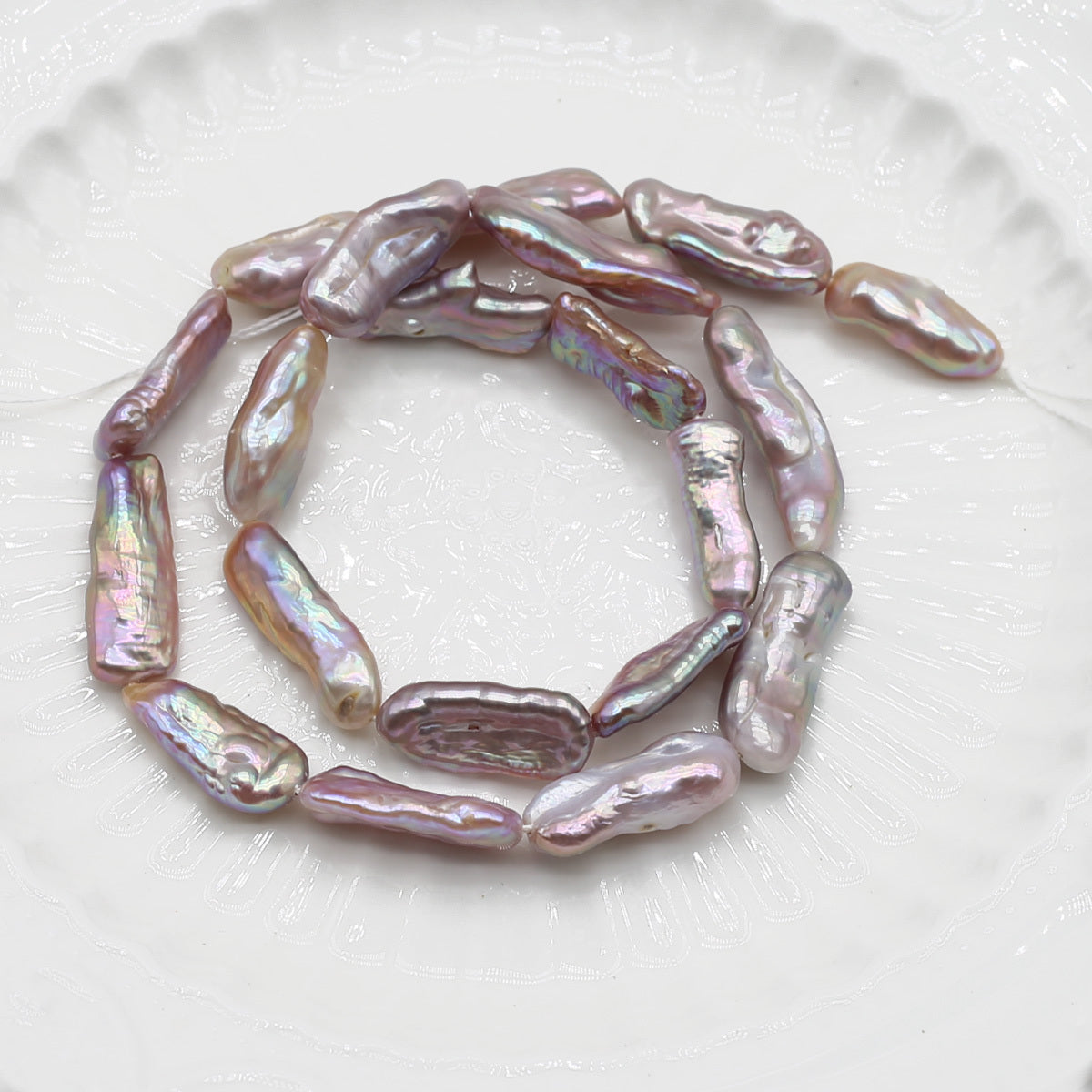 String of pink freshwater pearls on a white plate