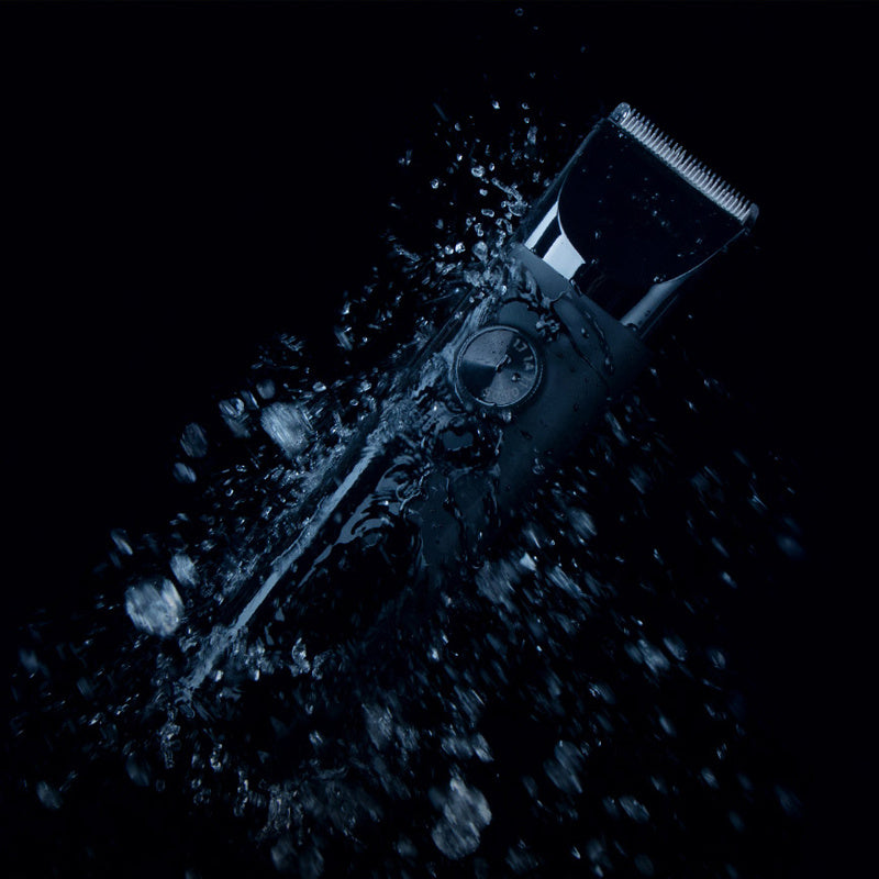 Hair clipper with water splashes on a black background