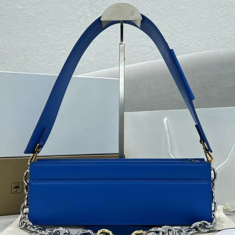 Blue handbag with a chain detail on a light gray background