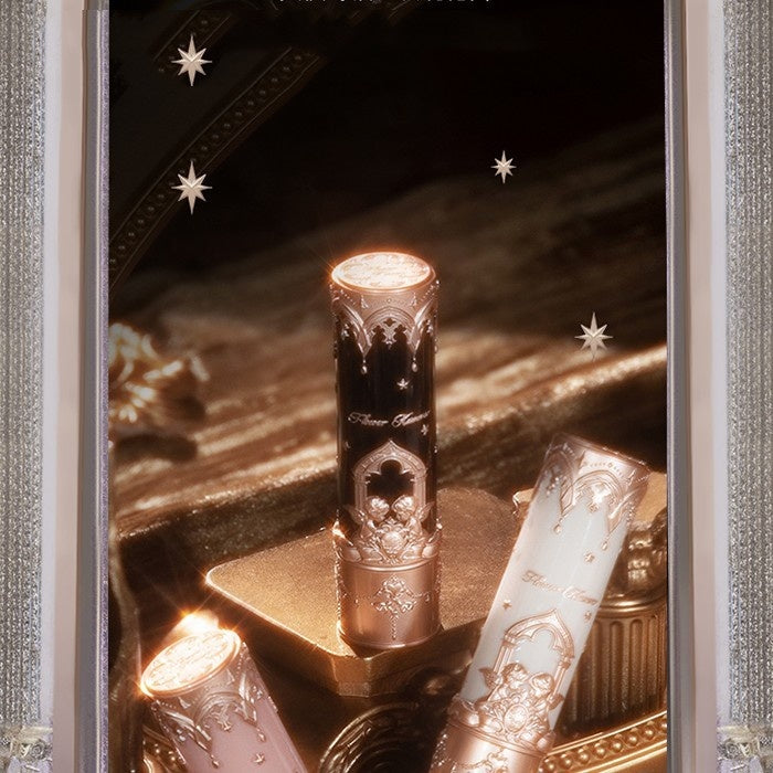 Decorative candles with intricate designs on a reflective surface