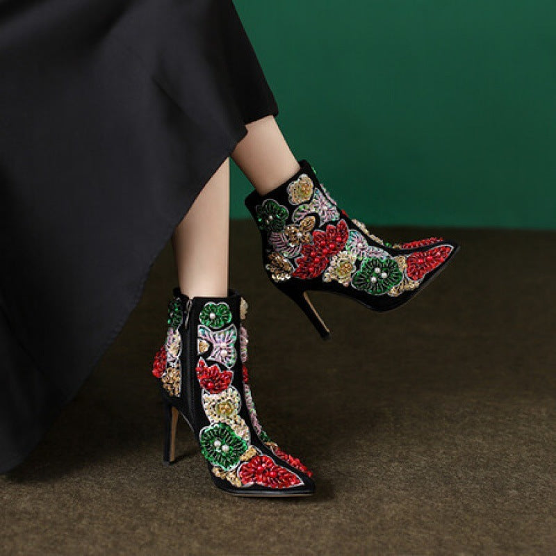 Decorative high-heeled shoes with colorful floral patterns on a dark background
