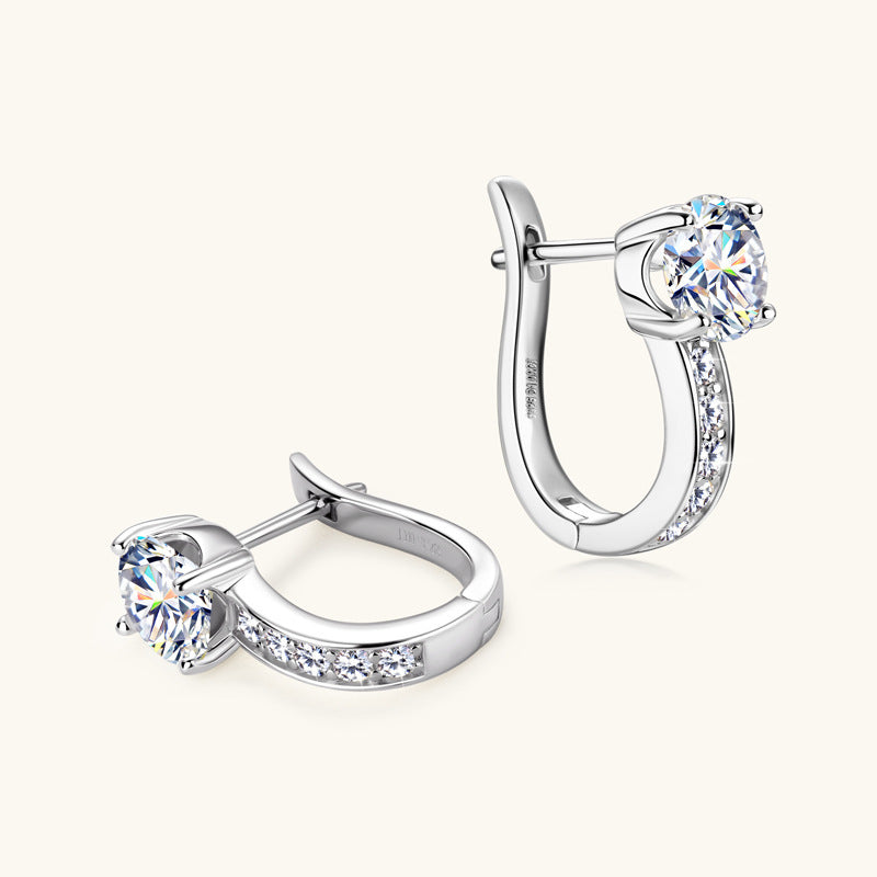 Pair of silver hoop earrings with clear gemstones on a white background