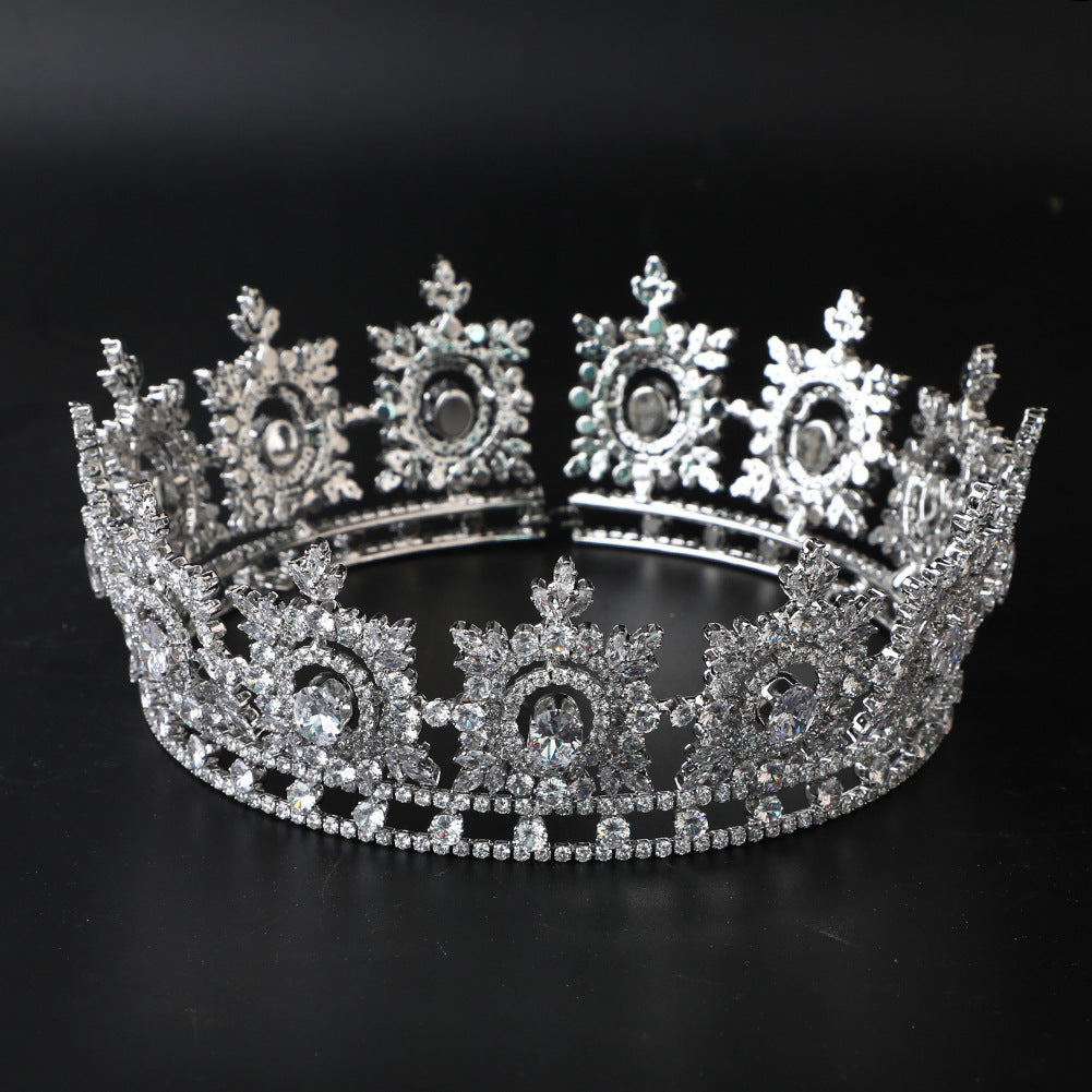 Silver tiara with intricate design on a black background