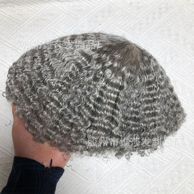 Curly gray wig held by a hand on a white textured background