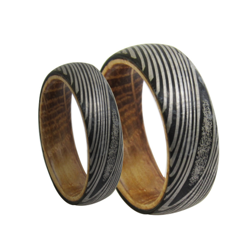 Two wooden rings with black and silver pattern on a white background