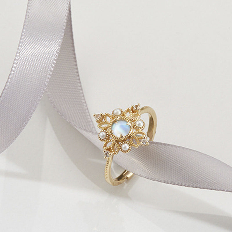 Gold ring with a central gemstone on a white ribbon