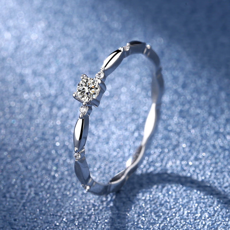 Silver ring with a diamond on a blue textured background