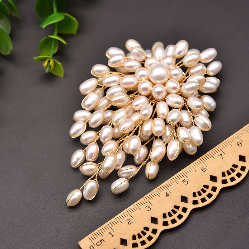 Pearl brooch with a ruler for scale on a dark background