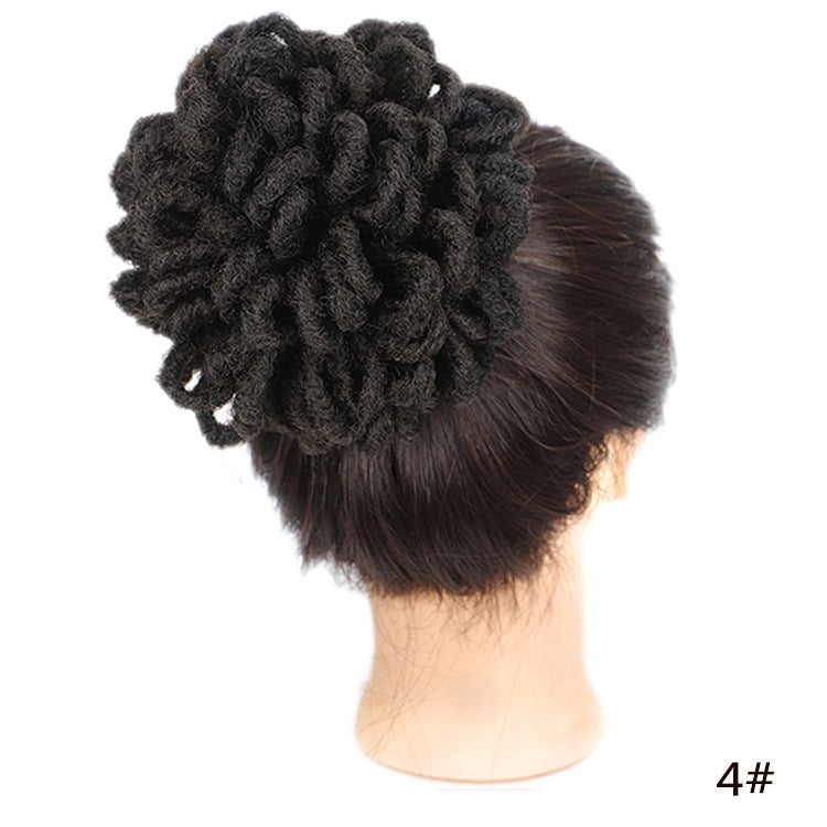 Black hair bun accessory on a mannequin head with a white background