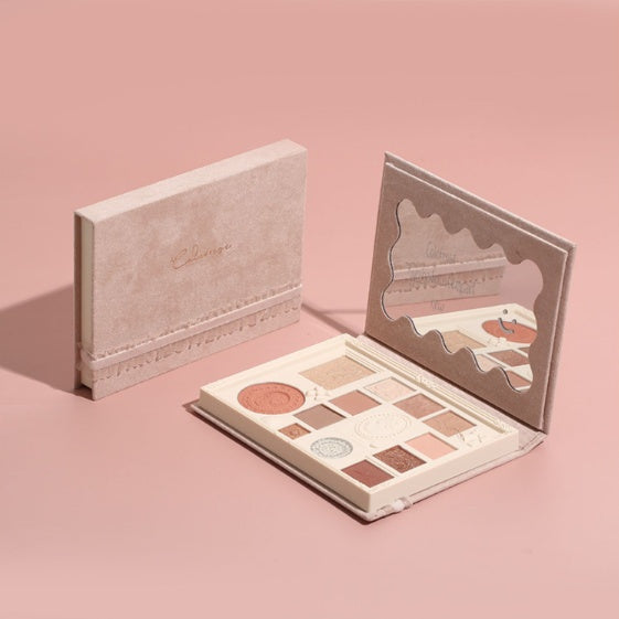 Makeup palette with open lid showing various shades on a pink background