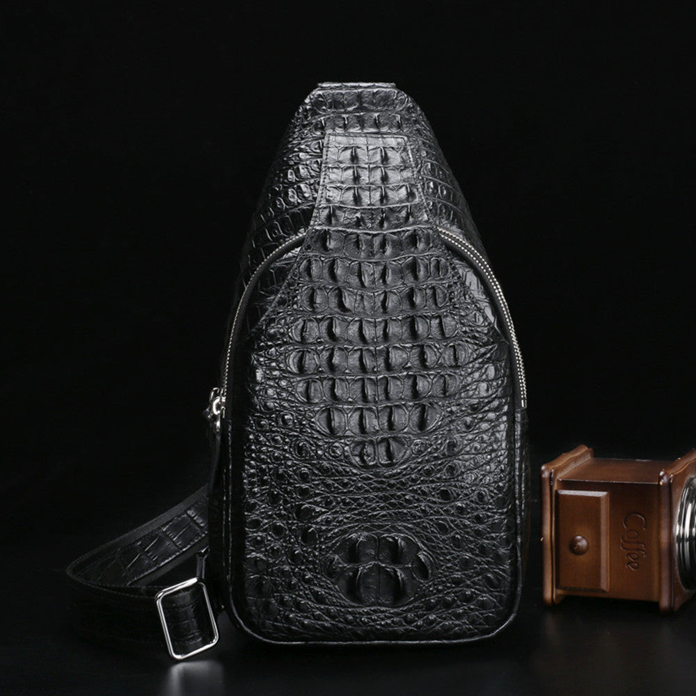 Black crocodile-patterned leather bag on a dark background