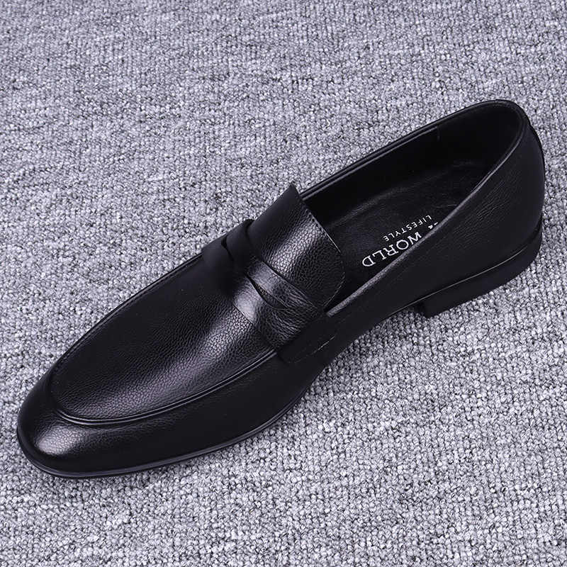 Black leather loafer shoe on a textured gray surface