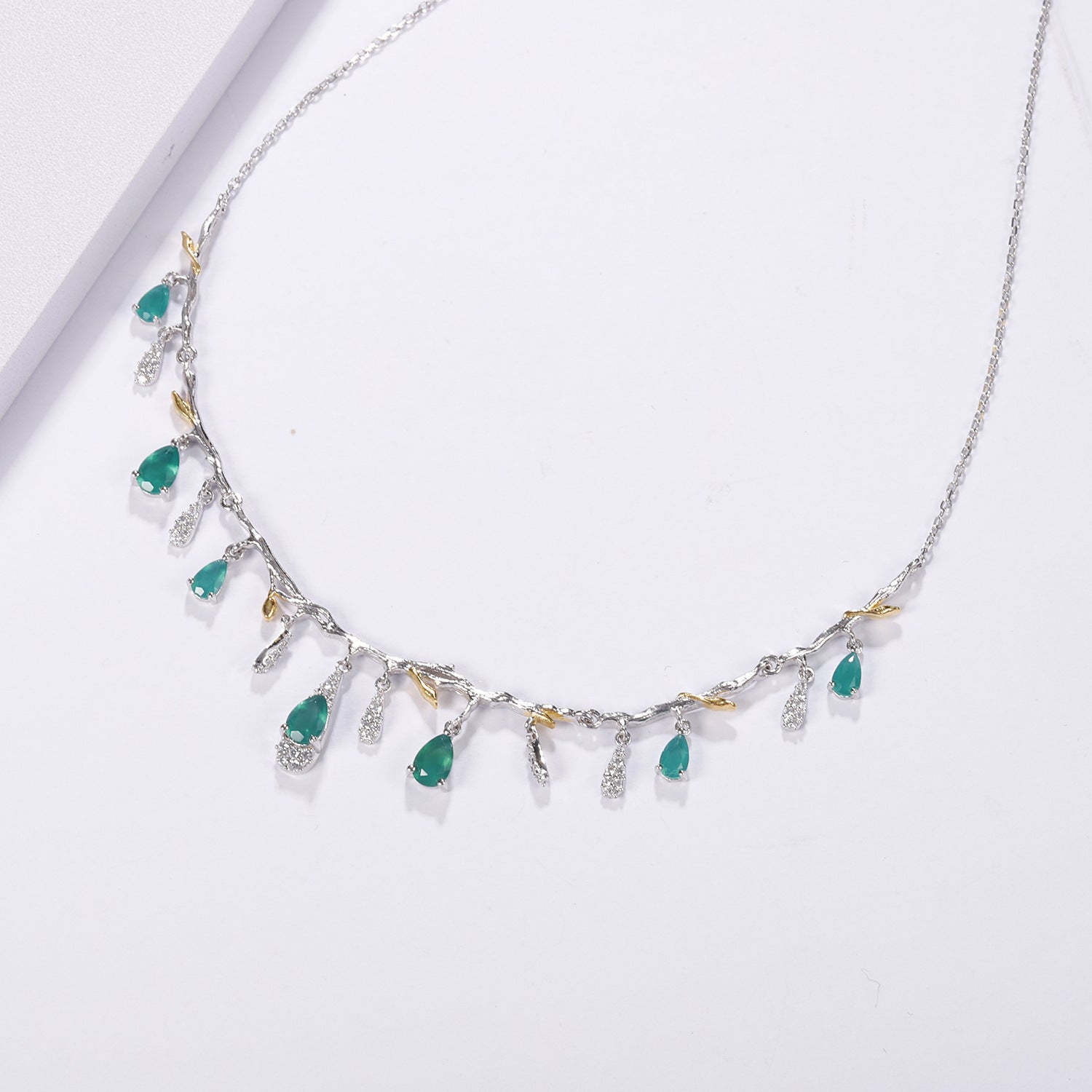 Necklace with green gemstones on a white background