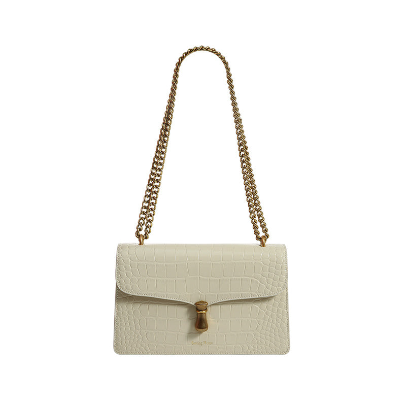 White handbag with gold chain strap on a white background