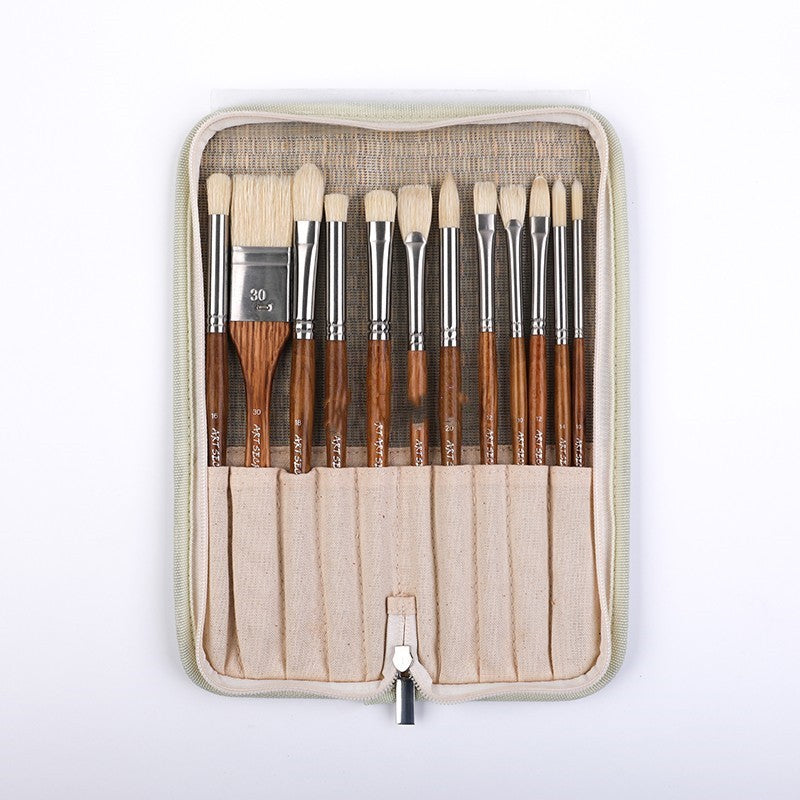 Set of paint brushes in a beige case on a white background