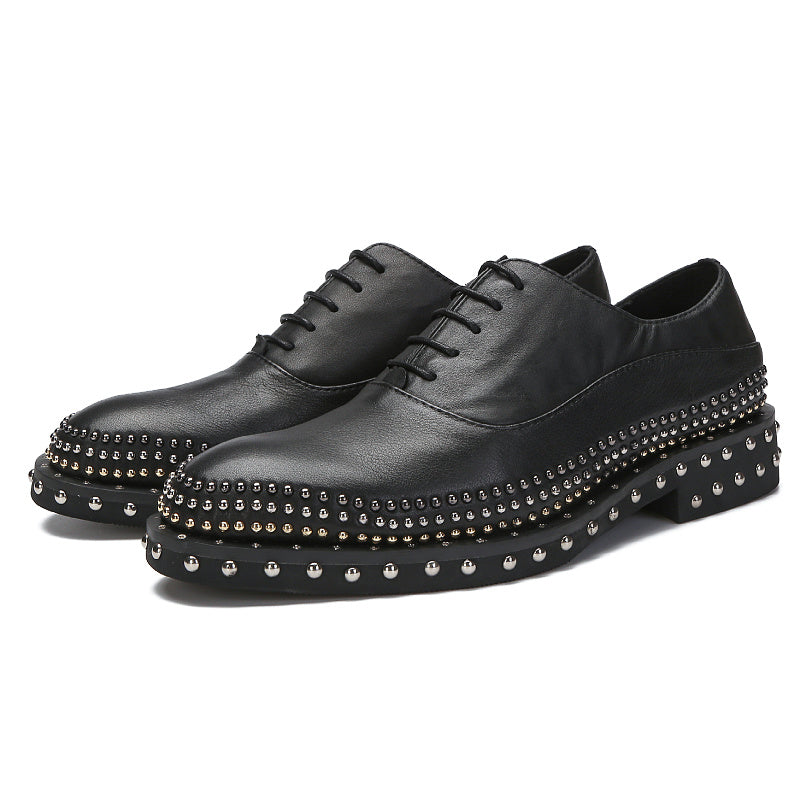 Black leather shoes with studded details on a white background