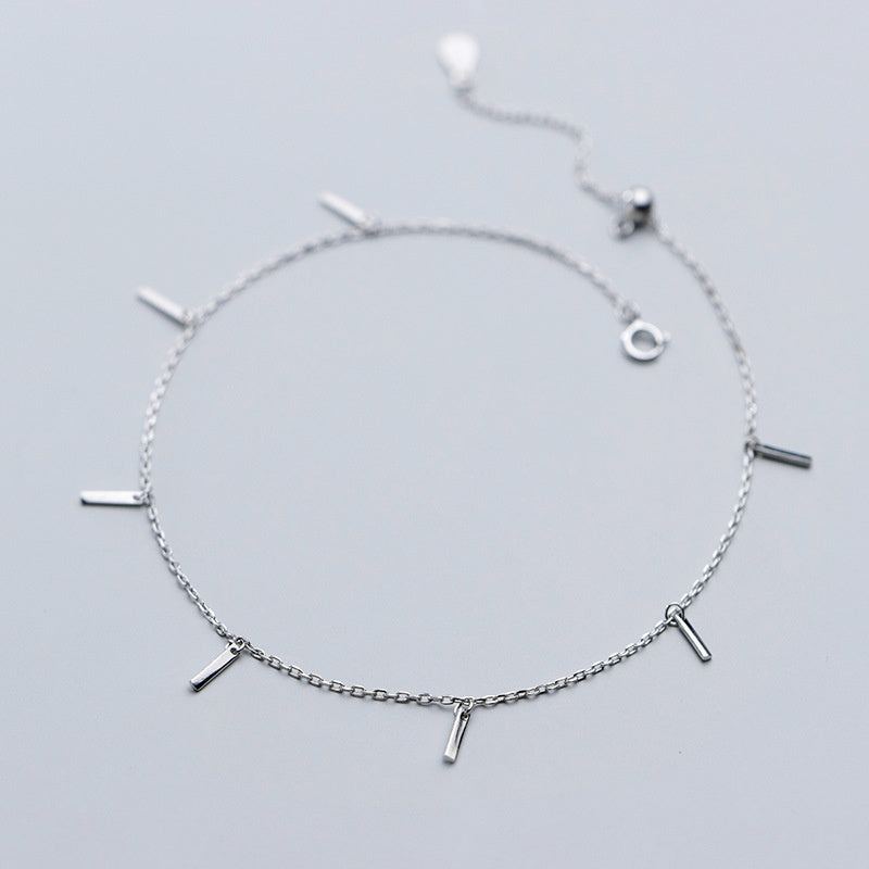 Silver bracelet with small bars on a light gray background