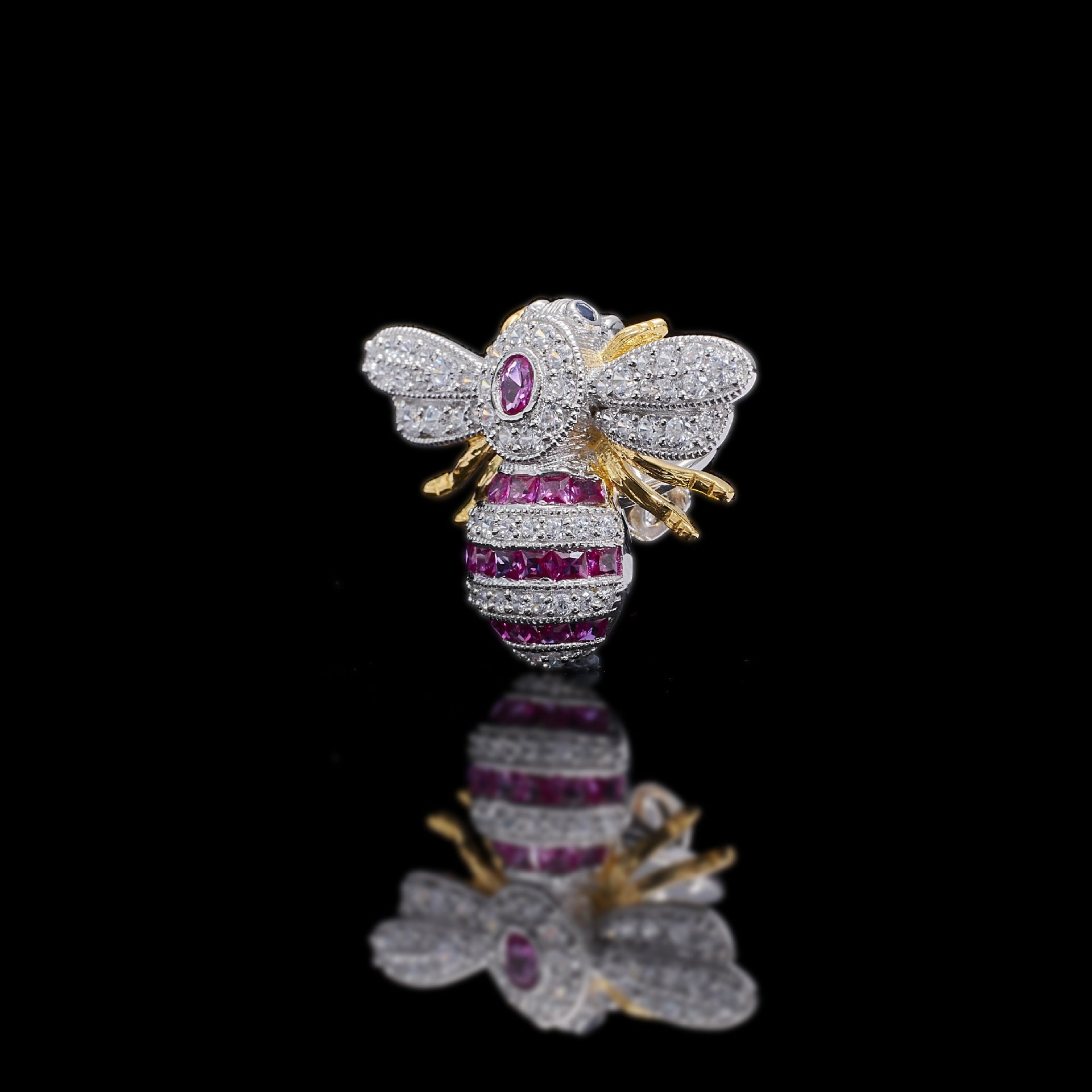 Jewelry item resembling a bee with gemstones on a black background